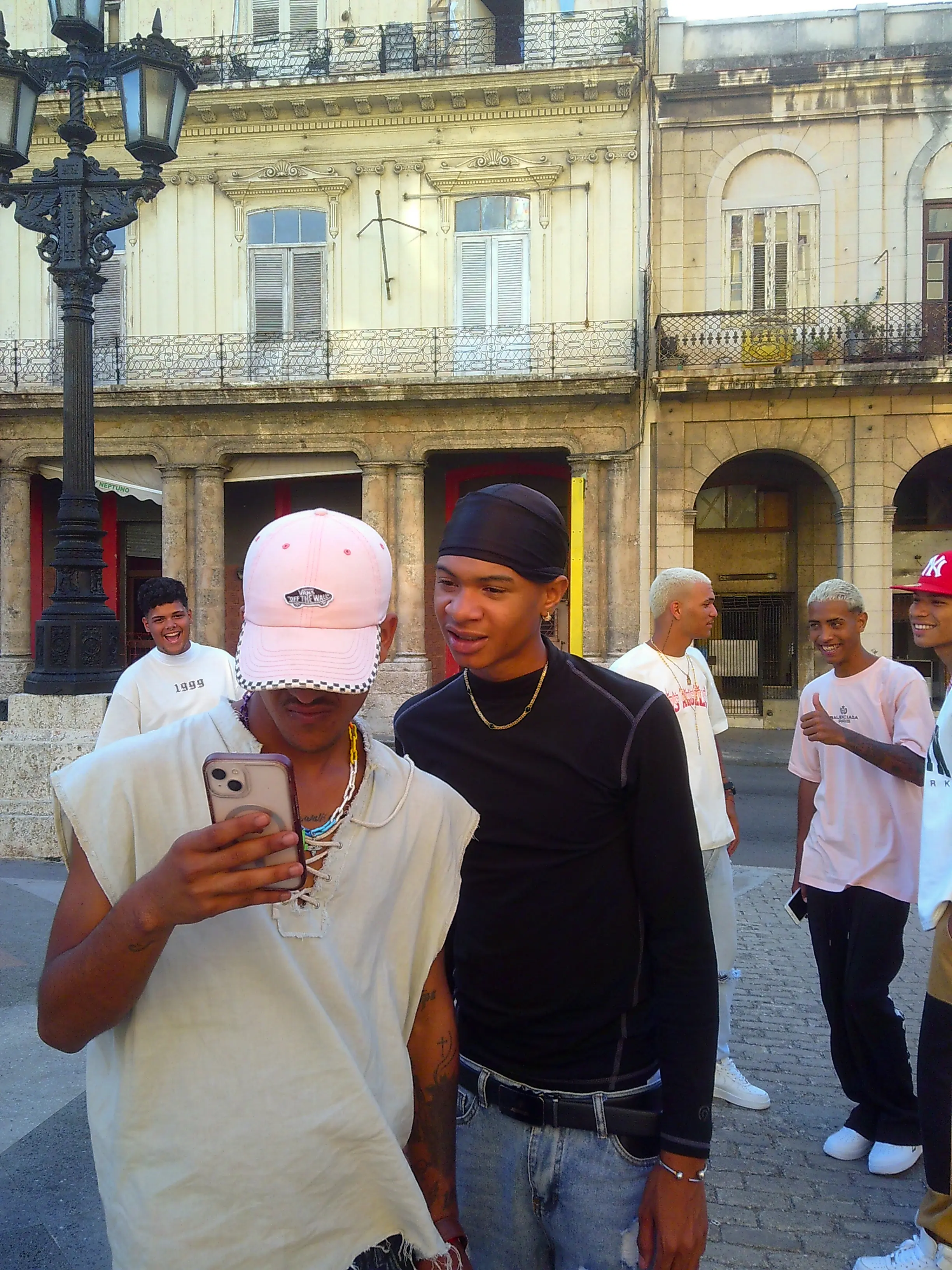 lads watching mobile phone on the street