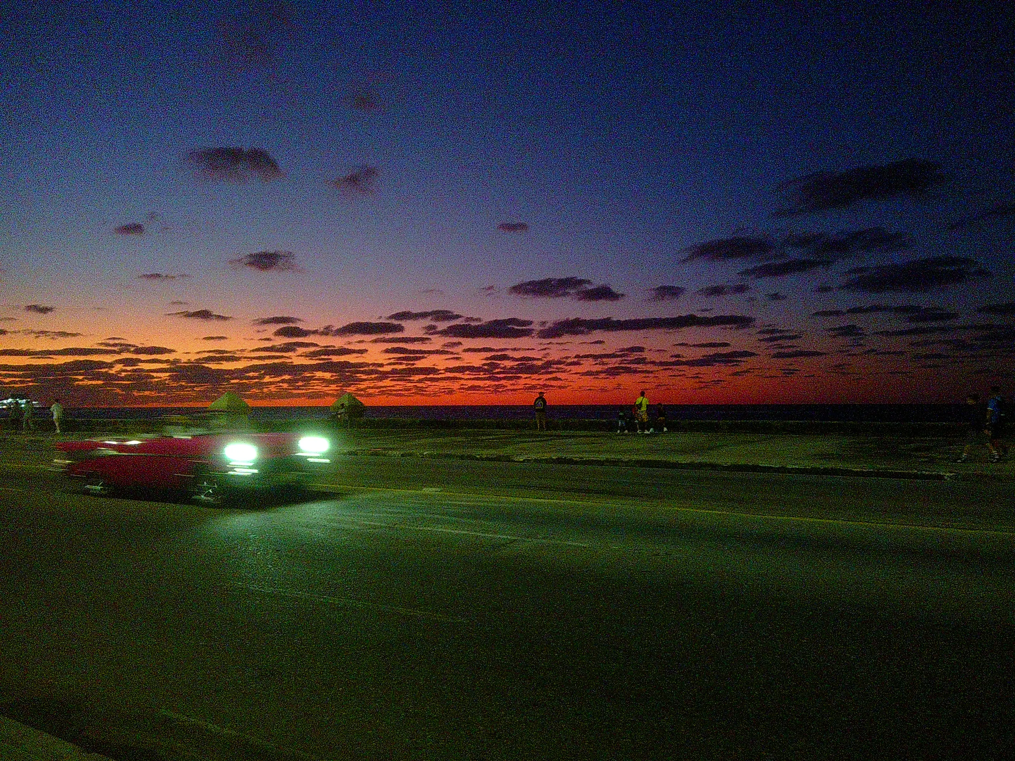 car running at dusk on Malecon