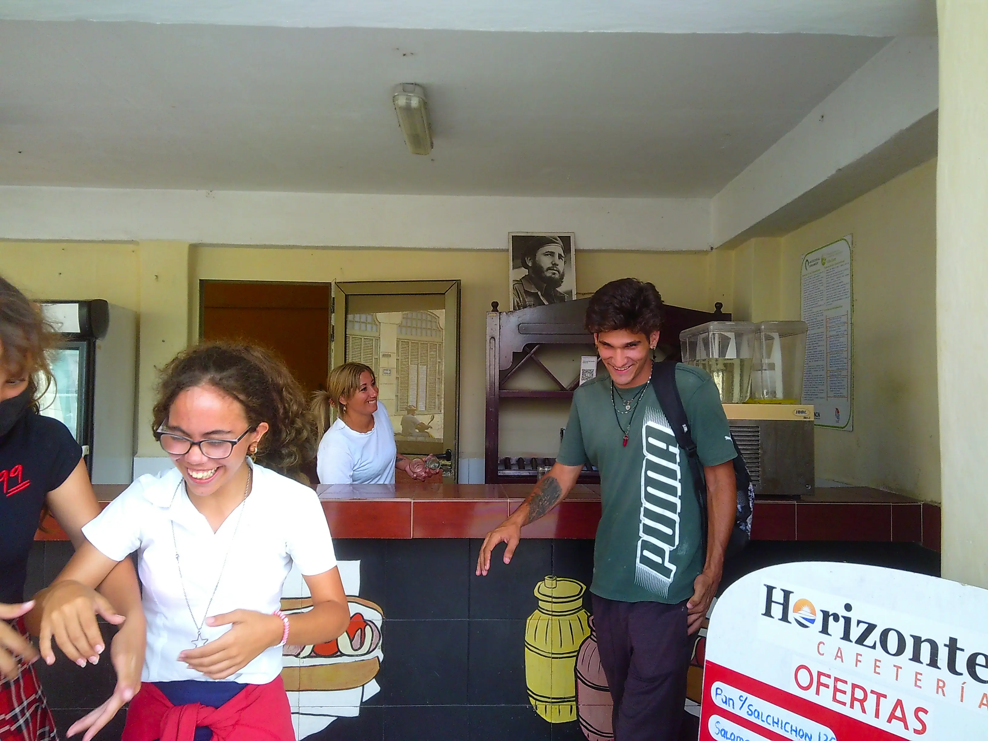 lads laugh inside an icecream shop under the sight of fidel castro photo