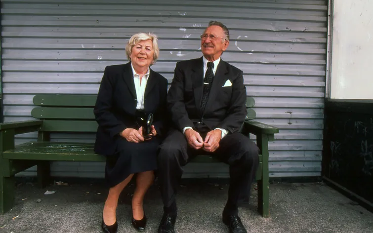 old couple elegant dresses at bus stop