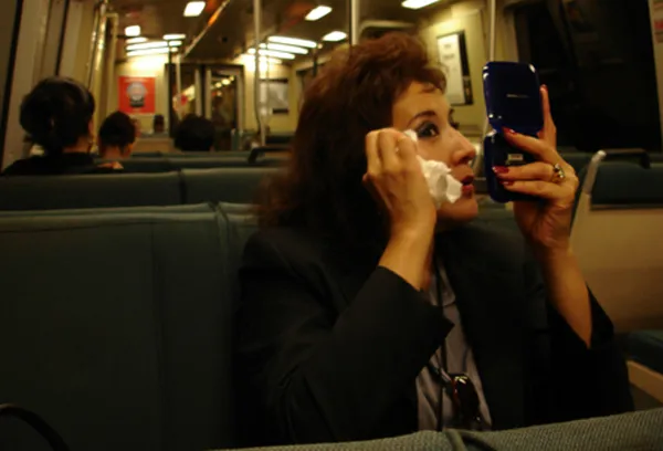 woman adjust her makeup on train