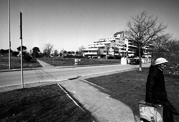 woman carries shopping bag at a cross road